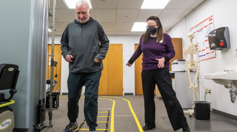 Neurorehabilitation volunteer help Parkinson's patient with physical therapy